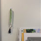 A keychain is shown being grabbed off of a hook on the wall, then placed in the pocket of a purse. Multiple different fabrics are then shown either being held in the hand or in the purse as a person walks to the door. 5 non spoonie fabric keychains are then shown on a white background.
