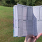 A video shows move left to right showing the main page of the normal size symptom journal. The book is then opening laying down and is flicked to different pages to show what is in the book. The pages shown in order are the month page, main tracking page,then in the back medication and test history, doctor information, and lined pages