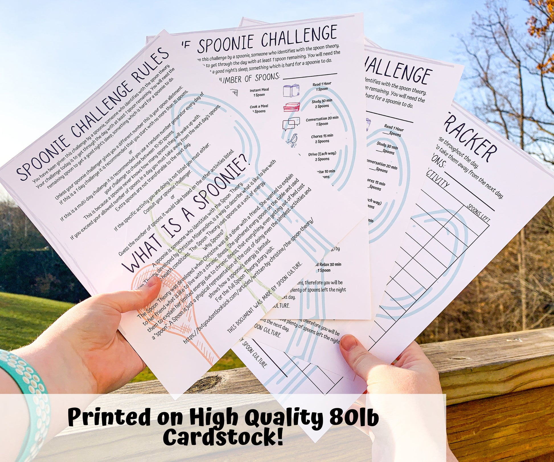Each page of the Spoonie Challenge set is shown being held up. They are unlaminated. A note says Printed on High Quality 80 pound cardstock. The pages in the set are the spoonie challenge rules and spoonie definition, 2 value pages with preset or blank values, and a spoon use tracker.