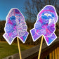 The word cloud and watercolor designs are shown on 2 sticks. Both ribbons feature purple borders with a magenta center color awareness ribbon with a brain in the center that has a lightning bolt on just the upper right side. The word cloud design on the left is split in half with a word cloud on the left half of the ribbon and right half of the brain.