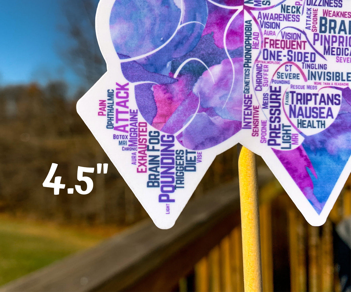 A close up of the 4.5 in word cloud ribbon is shown. You can see the words clearly in matching shades of purple and magenta. The words are things Aura, Chronic, Botox, Light, Vise, Tingling, Triptans, Pressure, Phonophobia, Genetics, Pounding, Rescue Meds, and more.