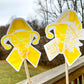 The word cloud and watercolor designs are shown on 2 sticks. Both ribbons are yellow with a shape in the center, the left watercolor one is a full uterus with barbed wire and the word cloud is half uterus and barbed wire and half sunflower. The word cloud design on the left is split in half with a word cloud on the left half of the ribbon and right sunflower half. The right watercolor ribbon is all color with a white border around the uterus for definition.