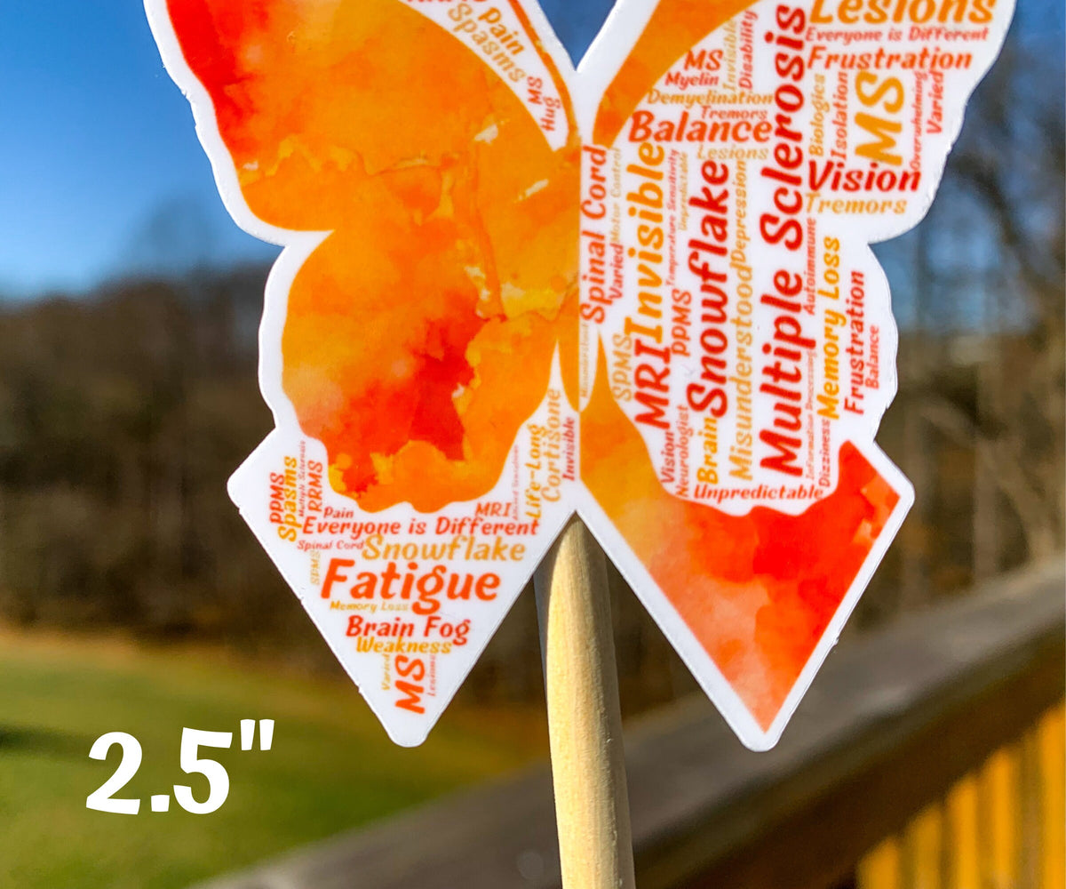 A close up of the 2.5 in word cloud ribbon is shown. You can see the words matching shades of orange, some of the smaller words are hard to see however this may be photo quality. The words are things like Snowflake, Multiple Sclerosis, Balance, Invisible, Spinal Cord, Lesions, Vision, Remors, Fatigue, Weakness, Spasms, and more.