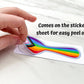A hand is shown peeling off the progressive pride sticker from the sticker paper. A note says comes on the sticker sheet for easy peel off.