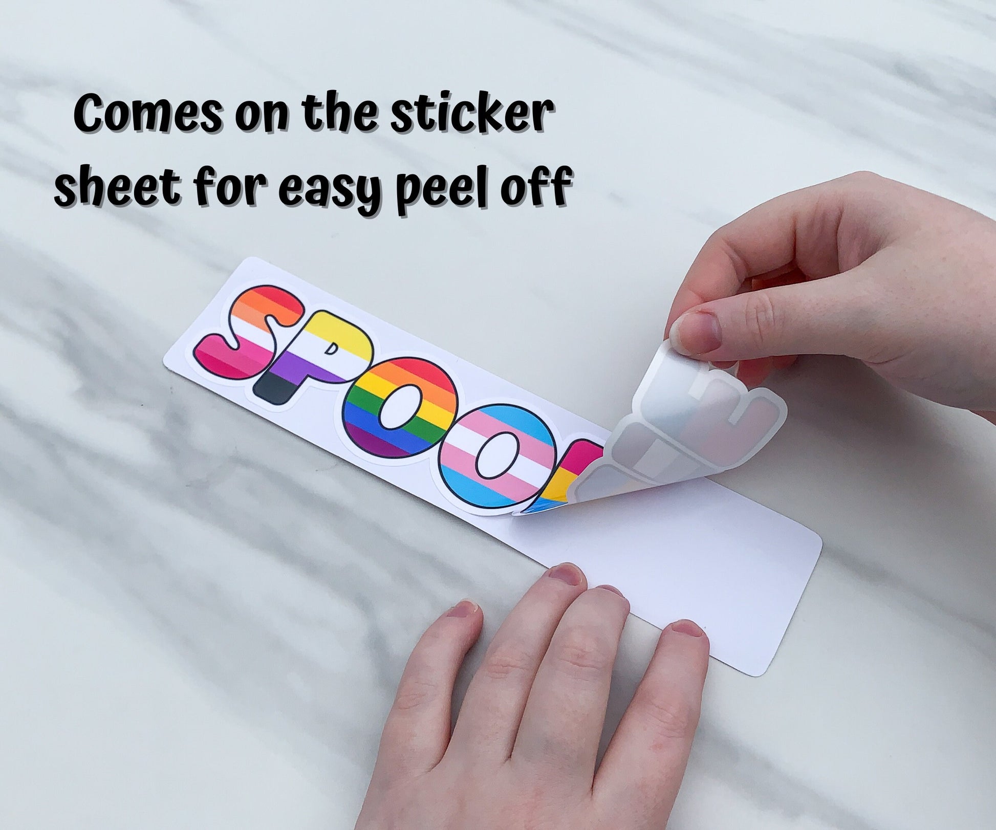 The spoonie sticker is shown being peeled off of the sticker paper backing. A note says the sticker comes on the sticker sheet for easy peel off. 